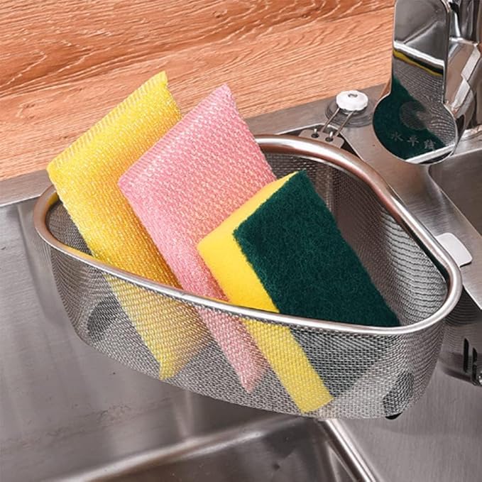 Metal sponge holder with colorful sponges inside a kitchen sink.