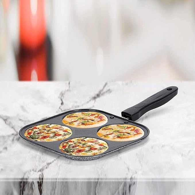 Black pizza pan with four sections, each containing a mini pizza, on a marble surface.