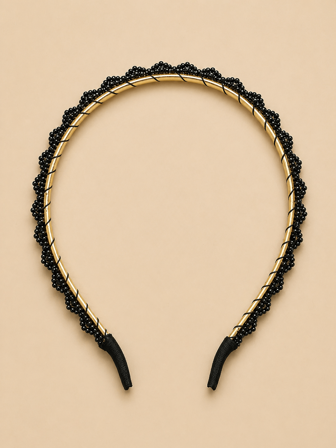 Elegant black beaded headband showcasing a gold metallic frame, perfect for stylish hair accessory collections.