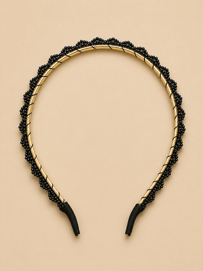 Elegant black beaded headband showcasing a gold metallic frame, perfect for stylish hair accessory collections.