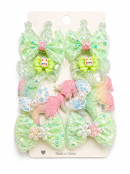 Pastel-colored hair bows with decorative elements on a white card.
