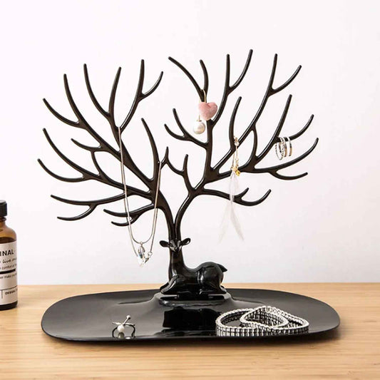 Black deer antler jewelry organizer with necklaces, rings, and bracelets on wooden surface